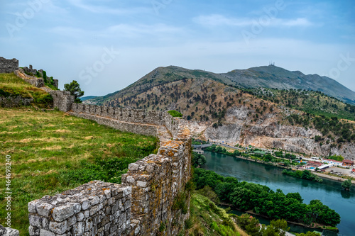 A hill on the coast of the Buna River - view from the observation deck of Rozafa Castle (Shkoder, Albania). Ancient stone wall against the backdrop of a beautiful mountain landscape
