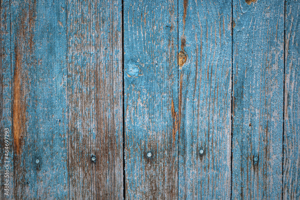 Naklejka premium Old wooden fence with peeling paint close-up