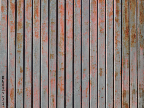 Grunge gray and red rusty metallic background. Textured structure made with metal rusty slats. Striped pattern