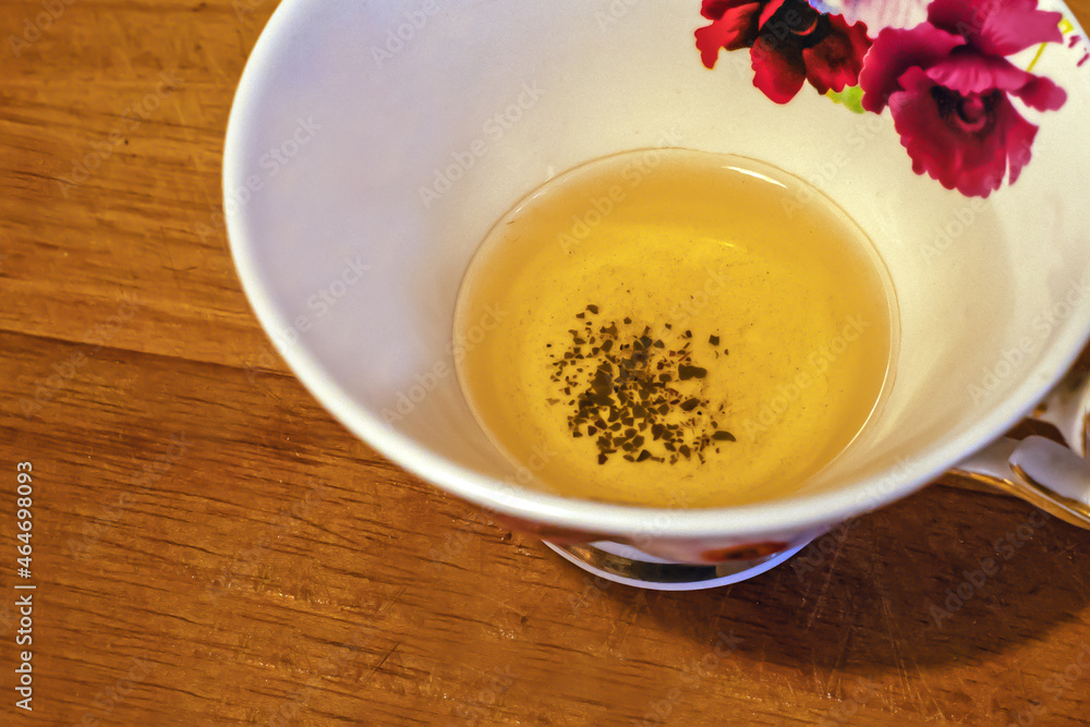 Fragment of a cup with unfinished green tea on a wooden surface Fragment of a cup with unfinished green tea on a wooden surface