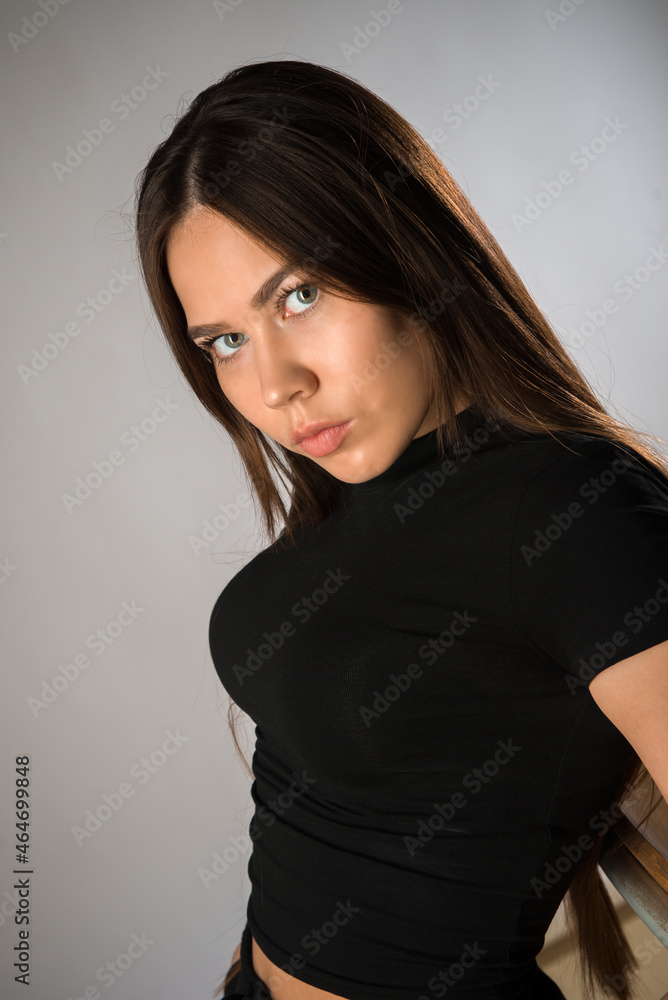 Naklejka premium Model with long hair posing in black suit on white background in studio. Fashion concept