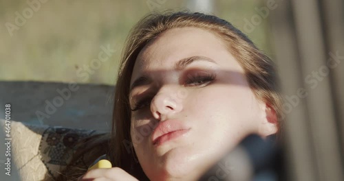 A young woman smokes e-cigarettes in an old car. The idea of modern youth. Defiant behavior as a way of pre-emptive aggression as a defense photo