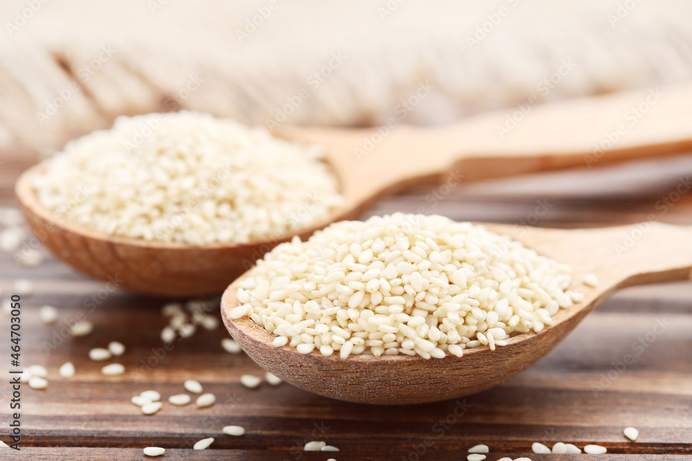 Sesame seeds in spoons on wooden background Sesame seeds in spoons on wooden background