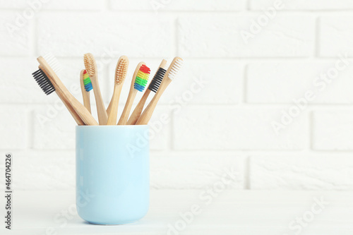 Toothbrushes in cup on brick wall background