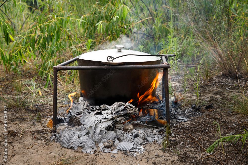 Bowler cooking food bonfire cauldron camp fire, pot. Hiking pot in the bonfire. Traveling in the mountains with tents. Bowler cooking food bonfire cauldron camp fire, pot. Hiking pot in the bonfire. Traveling in the mountains with tents.