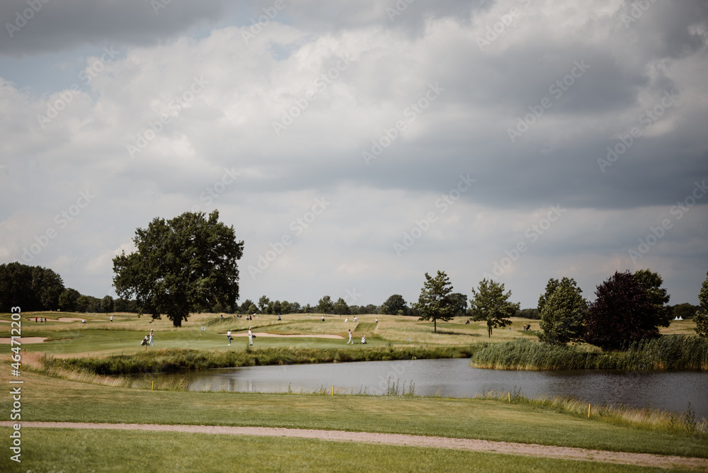 View of people on a golf course on a cloudy summer's day