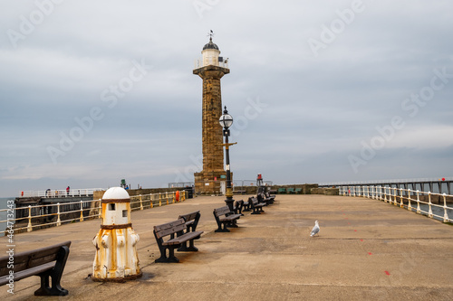  The lighthouse at the end of the West Pier in Whitby harbour on an overcast autumn day