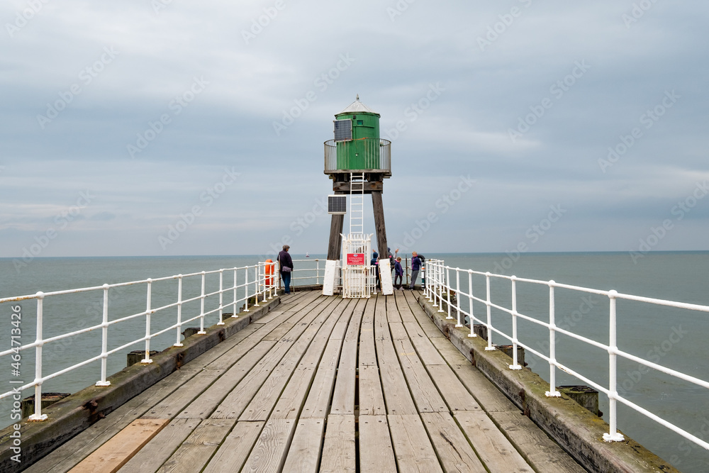 The green navigation light on Whitby pier captured on an overcast autumn day