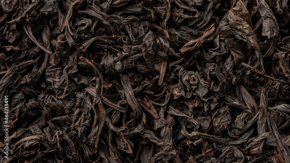 Heap of dry tea leaves. Dried black tea. Textured background of dried leaves of aromatic black tea with cinnamon