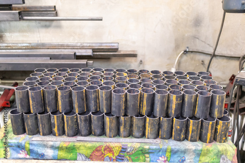 Round pipes are cut into short pieces and stacked neatly in a locksmith's shop.