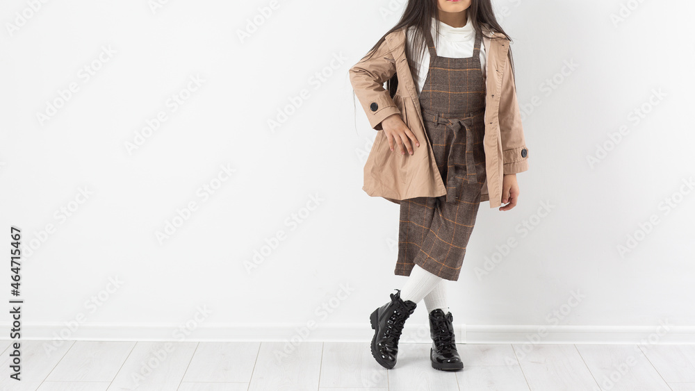 Attractive girl in checkered overalls on a white background. Catalog, clothing magazine.