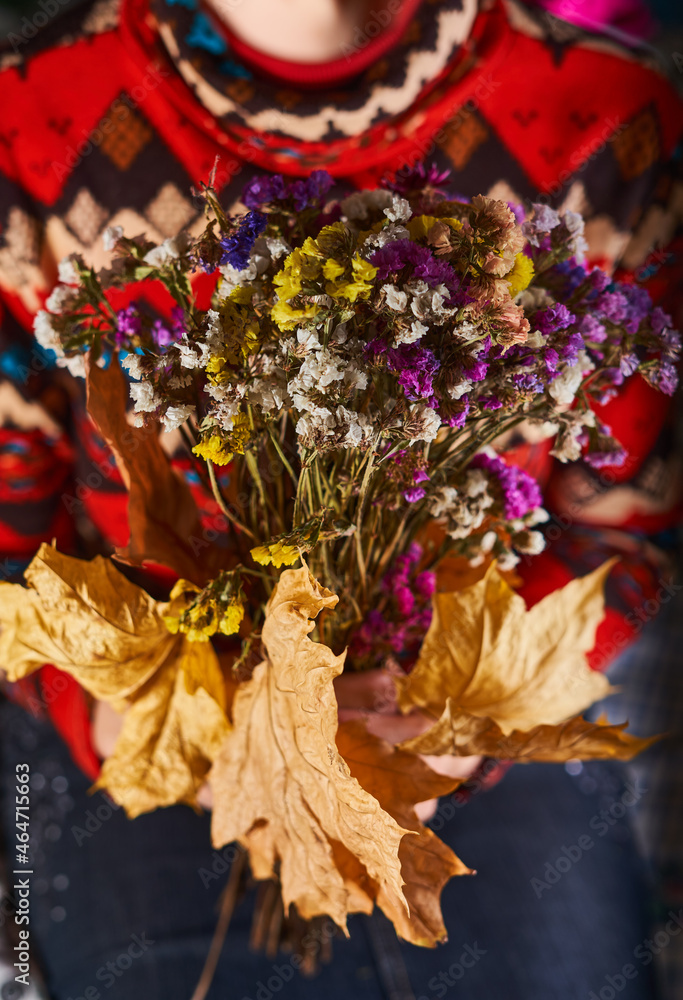 Dry bouquet of flowers in the woman's hands