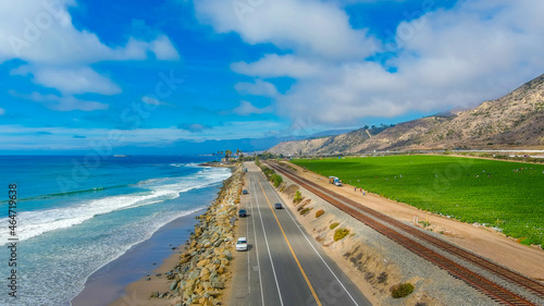 Tableau sur toile a breathtaking aerial shot of the vast blue ocean water, lush green farmland, ca