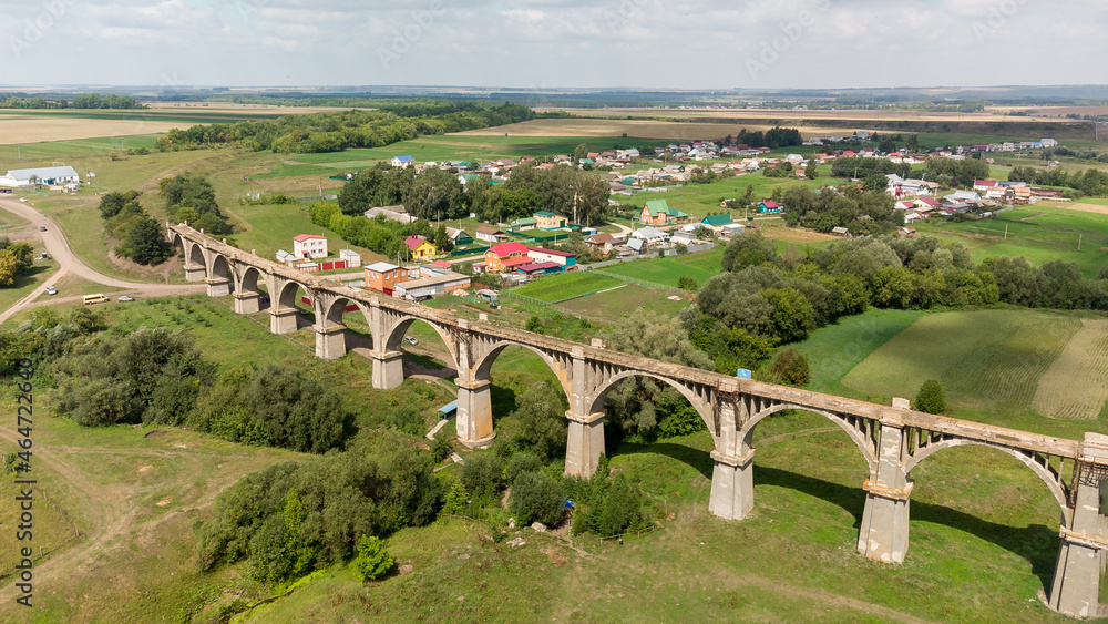 an old abandoned railway bridge with arches shooting from a drone