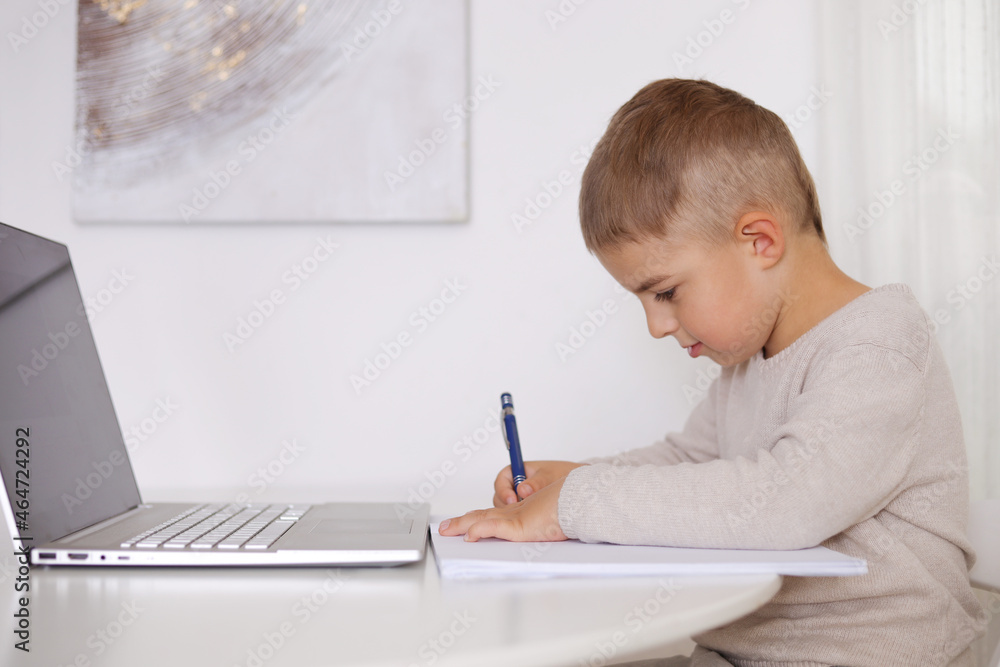 Little boy learning with a laptop at home. Online education and e-learning concept. Home quarantine distance learning. Modern kid and education technology. Little boy learning with a laptop at home. Online education and e-learning concept. Home quarantine distance learning. Modern kid and education technology.