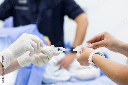 nurses introducing a dose of medicine into the needle