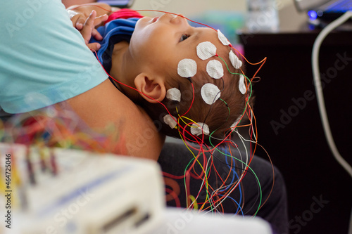 calmed baby lying down being examined with wires on his head photo