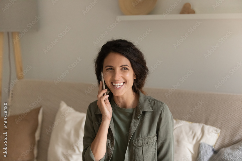 Happy joyful Hispanic woman with mobile phone making call, having nice talk at home, sitting on couch in living room, chatting, laughing, making order, consulting customer support service. Happy joyful Hispanic woman with mobile phone making call, having nice talk at home, sitting on couch in living room, chatting, laughing, making order, consulting customer support service.