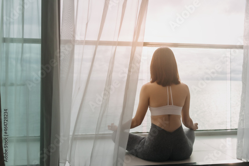 Asian woman meditate yoga asana on the balcony in the morning.