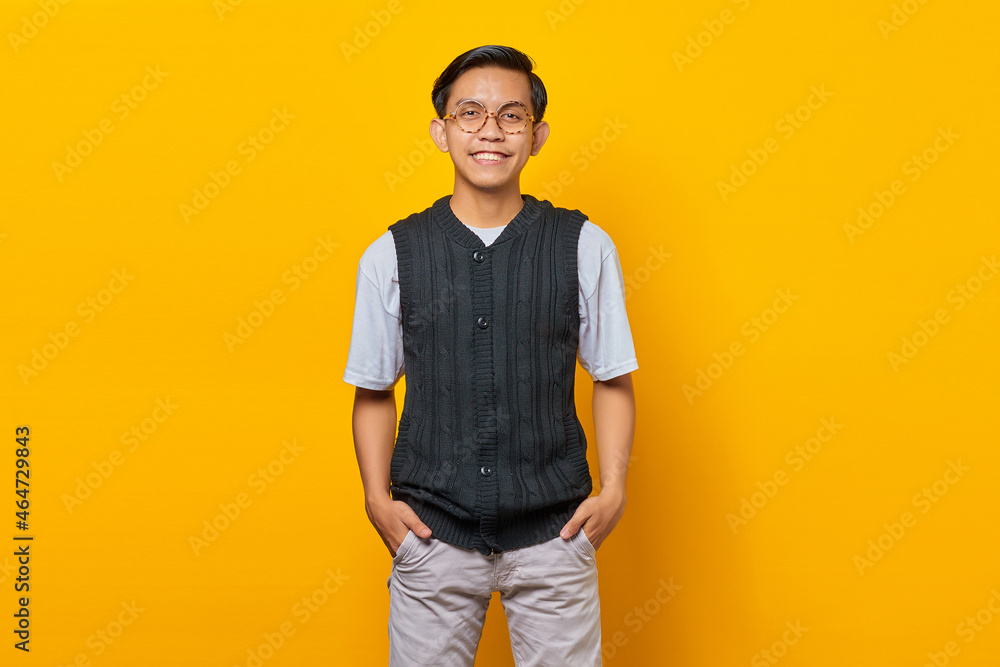 Portrait of handsome asian young man smiling looking at camera isolated on yellow background Portrait of handsome asian young man smiling looking at camera isolated on yellow background