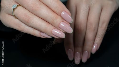 Womans hands with nude beige pink nail design. Manicure  fashion and beauty salon concept