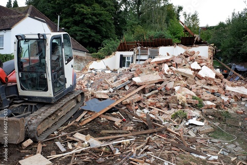 Φωτογραφία Digger and pile of rubble at house demolition site