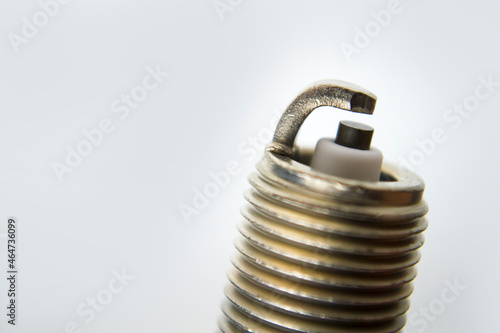 Auto service. New car spark plug as spare part of auto transportation on gray background.