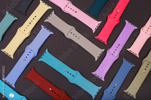 Colorful silicone straps for smart watches on a black background. Flat lay, different straps for watches
