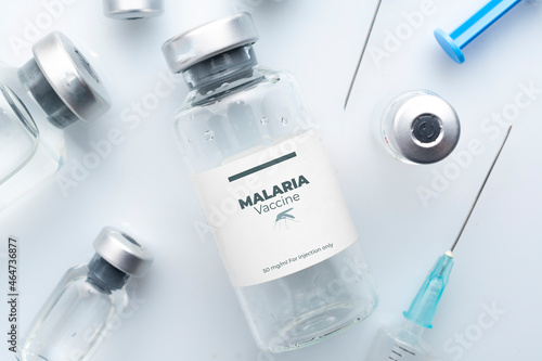 Malaria vaccine concept: vials and syringes on a white plane photo