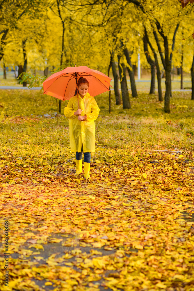 girl with an umbrella and rubber boots on an autumn walk