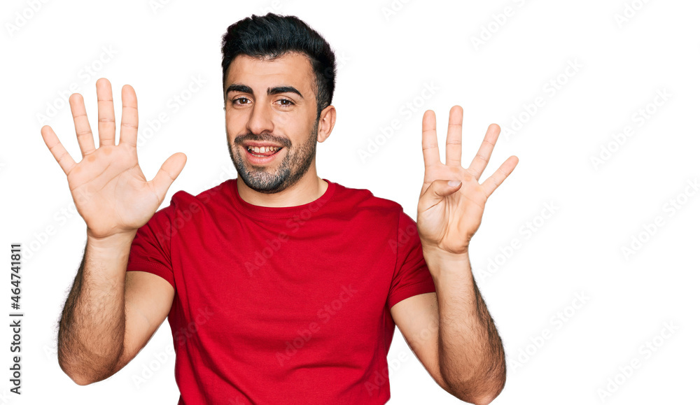 Hispanic man with beard wearing casual red t shirt showing and pointing up with fingers number nine while smiling confident and happy. Hispanic man with beard wearing casual red t shirt showing and pointing up with fingers number nine while smiling confident and happy.
