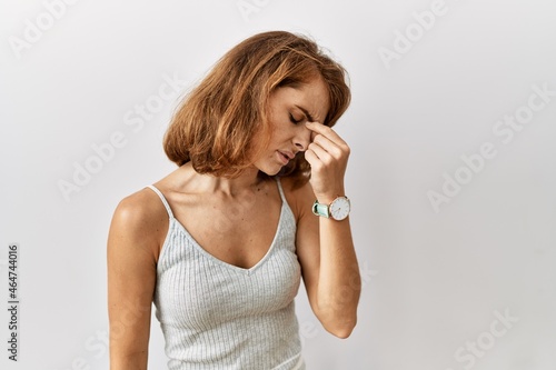 Beautiful caucasian woman standing over isolated background tired rubbing nose and eyes feeling fatigue and headache. stress and frustration concept.