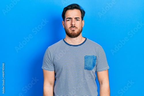 Handsome caucasian man with beard wearing casual striped t shirt depressed and worry for distress, crying angry and afraid. sad expression.