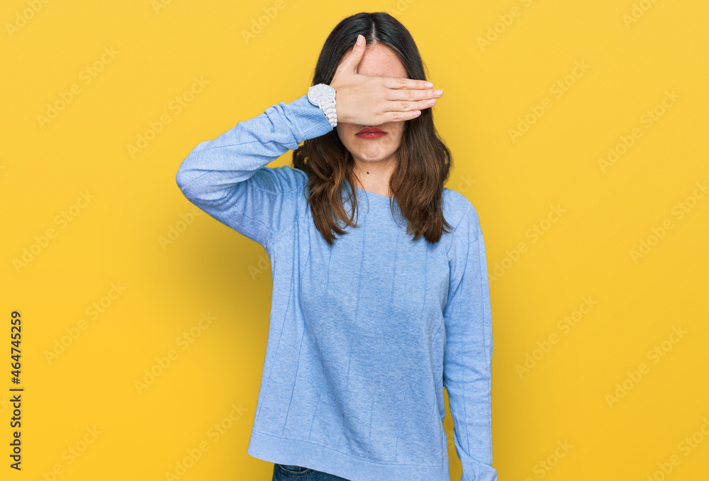 Young beautiful woman wearing casual clothes and glasses covering eyes with hand, looking serious and sad. sightless, hiding and rejection concept Young beautiful woman wearing casual clothes and glasses covering eyes with hand, looking serious and sad. sightless, hiding and rejection concept