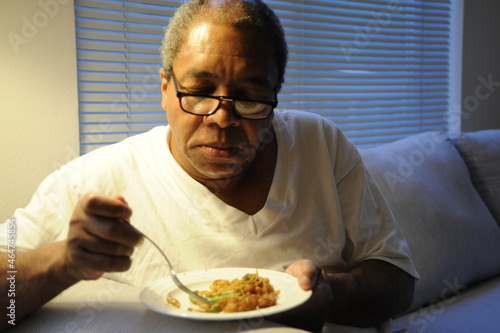 African american man eating dinner at home.