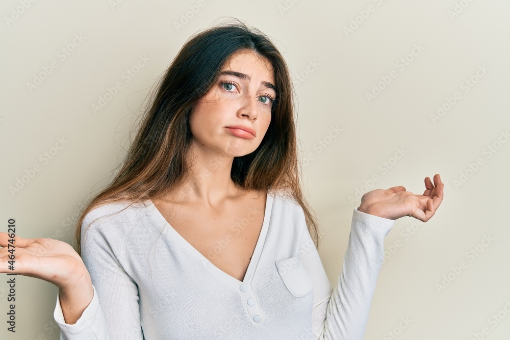 Young caucasian woman wearing casual white t shirt clueless and confused with open arms, no idea and doubtful face. Young caucasian woman wearing casual white t shirt clueless and confused with open arms, no idea and doubtful face.