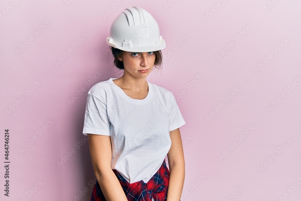 Young caucasian woman wearing hardhat skeptic and nervous, frowning upset because of problem. negative person. Young caucasian woman wearing hardhat skeptic and nervous, frowning upset because of problem. negative person.