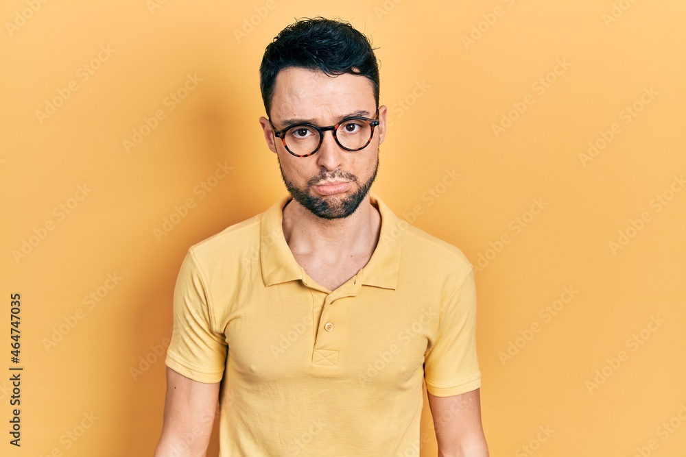 Young hispanic man wearing casual clothes and glasses depressed and worry for distress, crying angry and afraid. sad expression. Young hispanic man wearing casual clothes and glasses depressed and worry for distress, crying angry and afraid. sad expression.