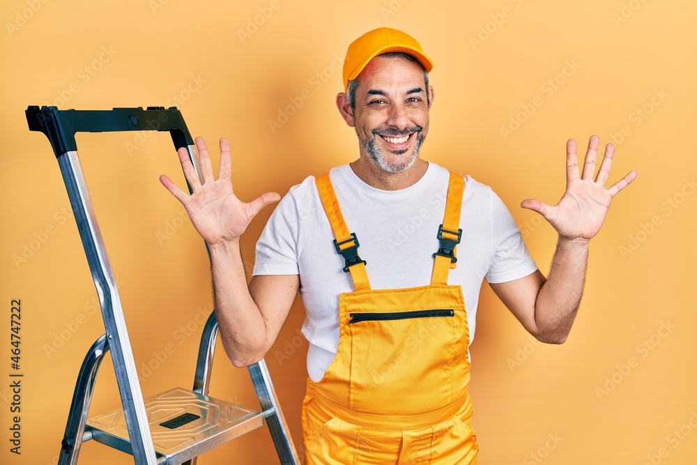 Handsome middle age man with grey hair holding ladder showing and pointing up with fingers number ten while smiling confident and happy. Handsome middle age man with grey hair holding ladder showing and pointing up with fingers number ten while smiling confident and happy.
