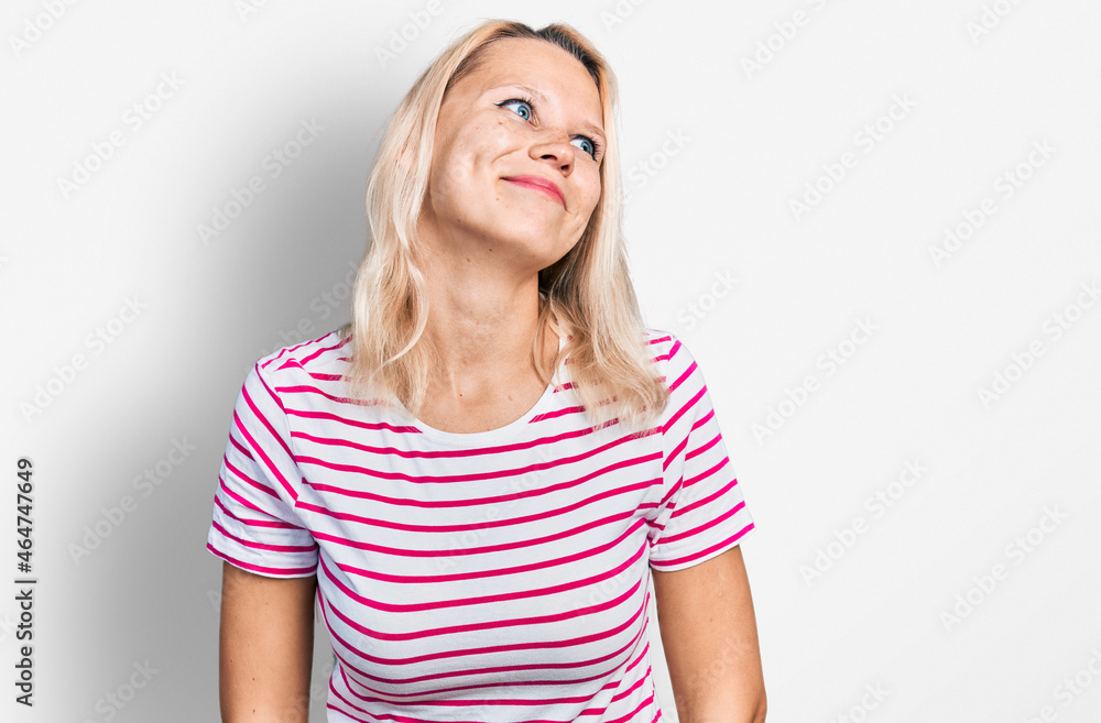 Young caucasian woman wearing casual clothes smiling looking to the side and staring away thinking. Young caucasian woman wearing casual clothes smiling looking to the side and staring away thinking.