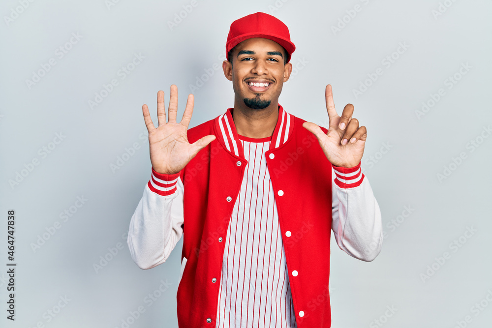 Young african american man wearing baseball uniform showing and pointing up with fingers number seven while smiling confident and happy. Young african american man wearing baseball uniform showing and pointing up with fingers number seven while smiling confident and happy.