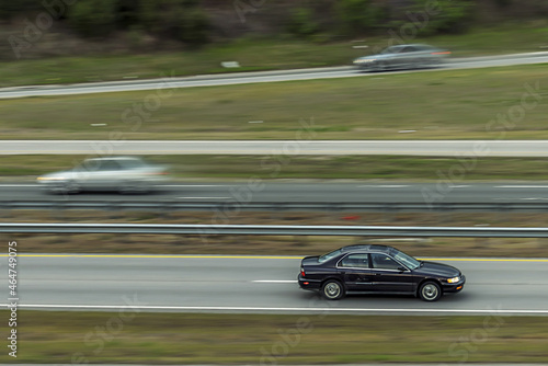 Car running fast on highway on a blurry background © Luis G. Vergara