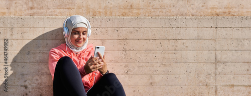 Fotografie, Obraz Muslim young woman with headphones taking a break