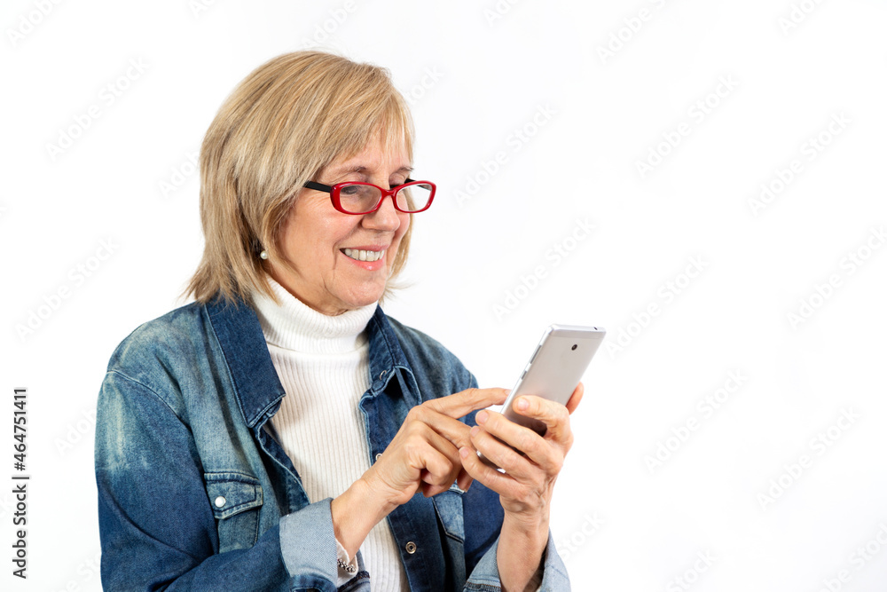 Senior woman with smartphone in her hands. White background. Copy space. Senior woman with smartphone in her hands. White background. Copy space.