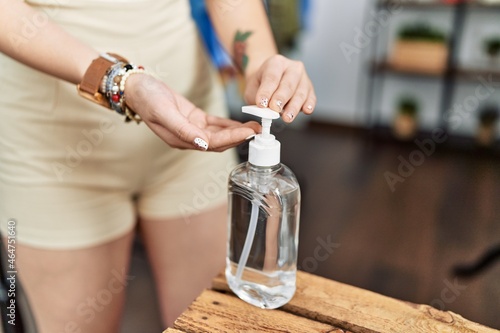 Young asian woman going shopping using sanitizer gel at retail shop