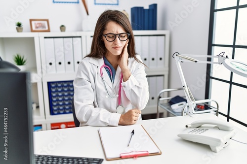 Young doctor woman wearing doctor uniform and stethoscope at the clinic touching mouth with hand with painful expression because of toothache or dental illness on teeth. dentist