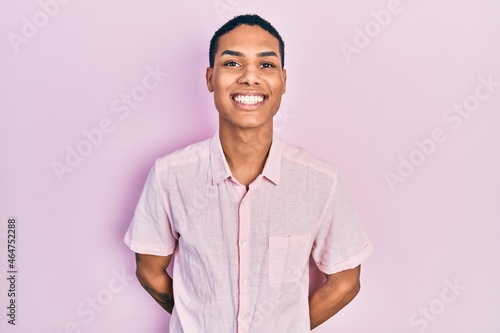 Young african american guy wearing casual clothes looking positive and happy standing and smiling with a confident smile showing teeth