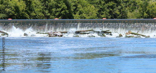rushing river damn system overflowing with trees and debris flooding flood disaster nature background