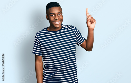 Konstfotografi Young african american man wearing casual striped t shirt smiling with an idea o