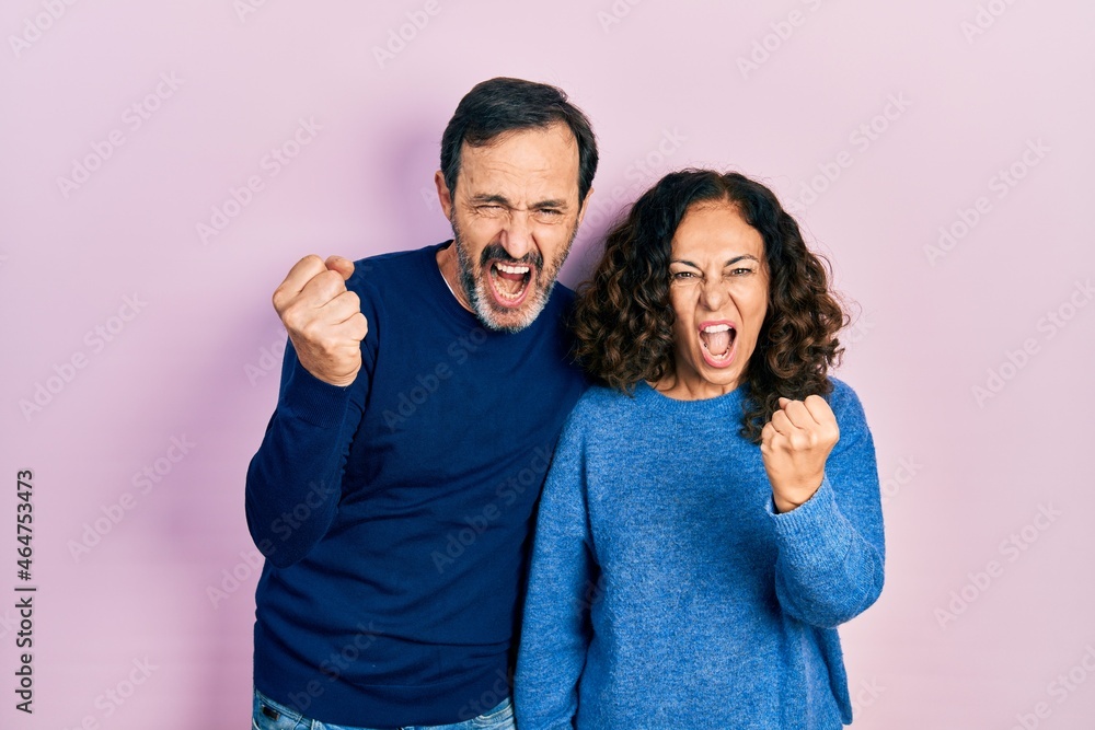 Middle age couple of hispanic woman and man hugging and standing ...
